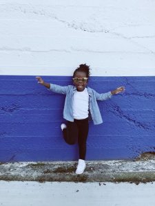 Girl poses for picture against the wall